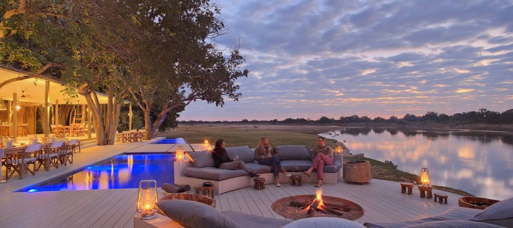 Sit around a campfire on the main deck overlooking the river's wildlife at Chinzombo, South Luangwa National Park, Zambia - Image 5