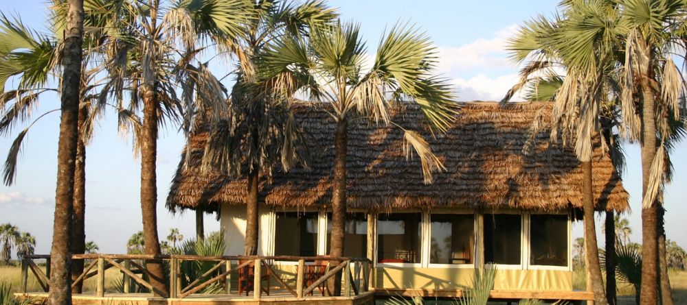 A guest tent shade by a grove of palm trees at Maramboi Tented Camp, Tarangire National Park, Tanzania - Image 1