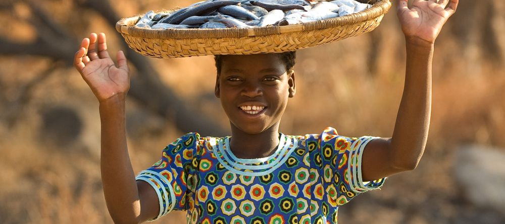 A local girl with preserved fish at Pumulani, Lake Malawi, Malawi - Image 3
