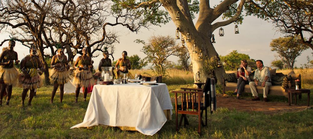 Savor dining at sunset while watching a traditional dance performance at Singita Sasakwa Lodge, Grumeti Reserves, Tanzania - Image 1