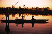 Boating at sunset at Sandibe Safari Lodge, Okavango Delta, Botswana
